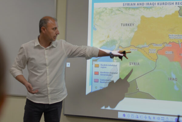 Bahjat Mohammed Hussein points to a map of Syrian and Iraqi Kurdish regions during a lunch and learn talk on the challenges and opportunities facing NE Syria's education system.